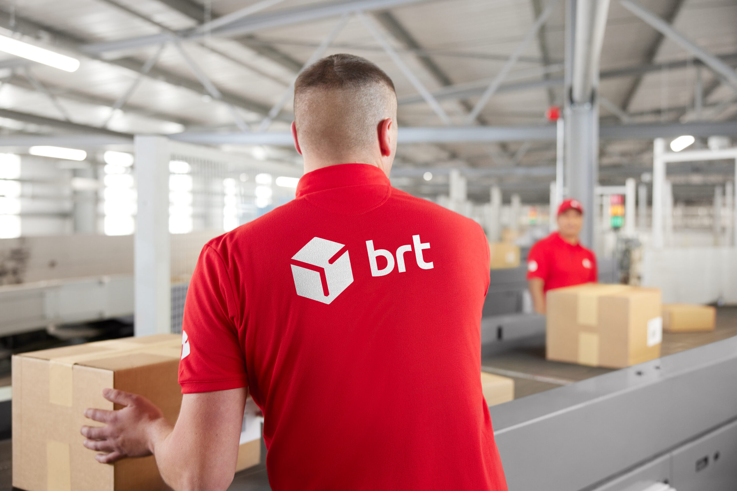 Employee with parcel at conveyor belt
